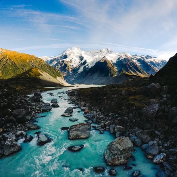 Der Mount Cook in Neuseeland, mit einem türkisfarbenen Fluss im Vordergrund.