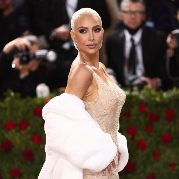 Kim Kardashian posiert in einem mit Schmucksteinen besetzten Kleid und einer weißen Stola.