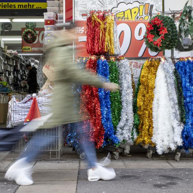 Eine Person geht an einem Geschäft mit Weihnachtsdekoration vorbei.