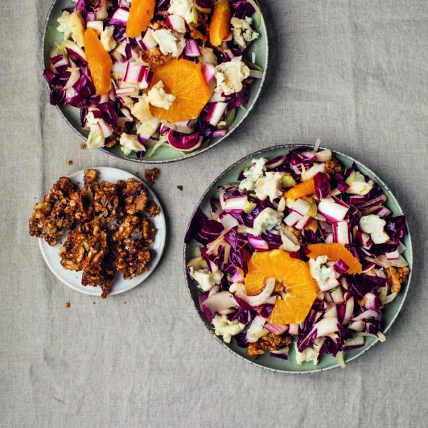 Zwei Teller Salat mit Radicchio, Orangen und Gorgonzola auf einem Tisch.