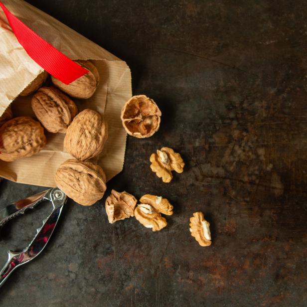 Walnüsse mit Schale in Papier, Nussknacker, offene Walnüsse ohne Schale