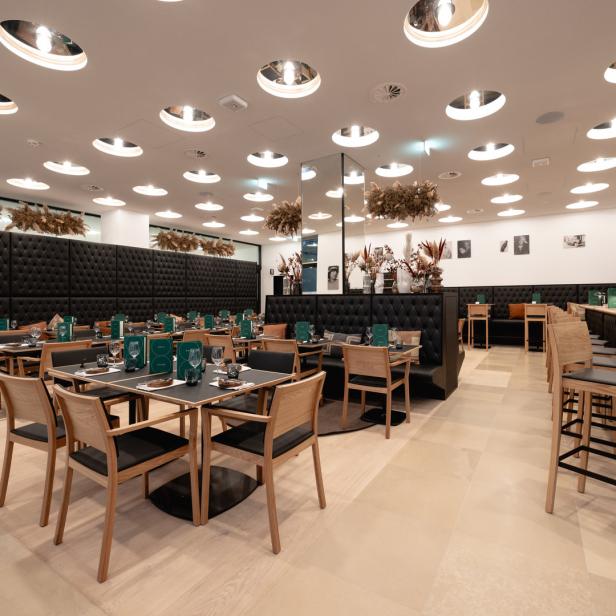 Ein elegantes Restaurant mit gedeckten Tischen und moderner Beleuchtung.