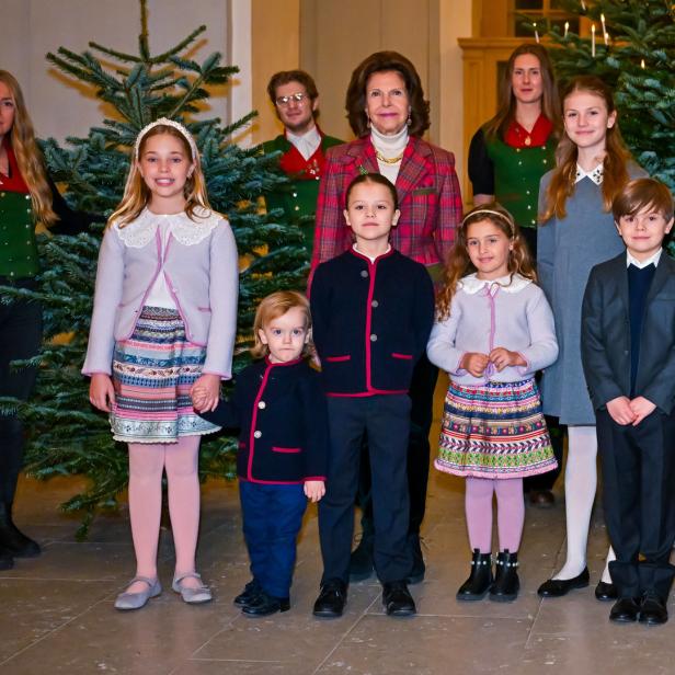 Die schwedische Königsfamilie posiert vor Weihnachtsbäumen.