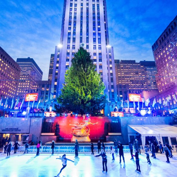 Menschen laufen auf der Eisbahn vor dem Rockefeller Center mit dem Weihnachtsbaum in New York.