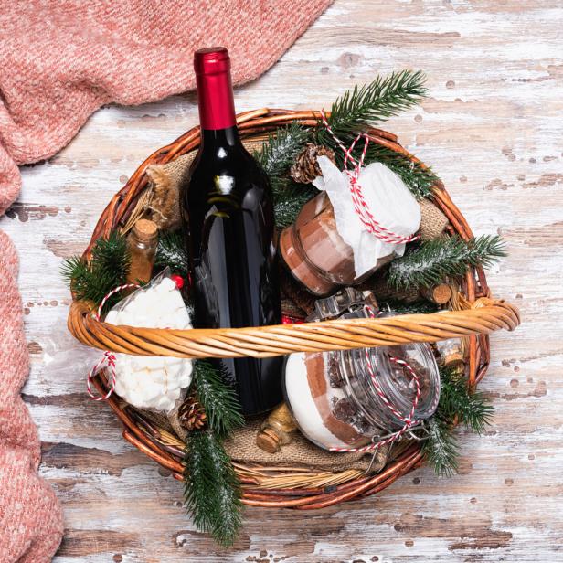 Rotwein und Konfektgläser in einem weihnachtlichen Präsentkorb.