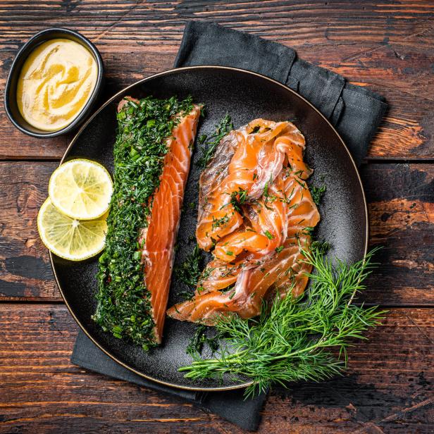 Gebeizter Lachs mit Dill und Zitronenscheiben auf einem Teller.