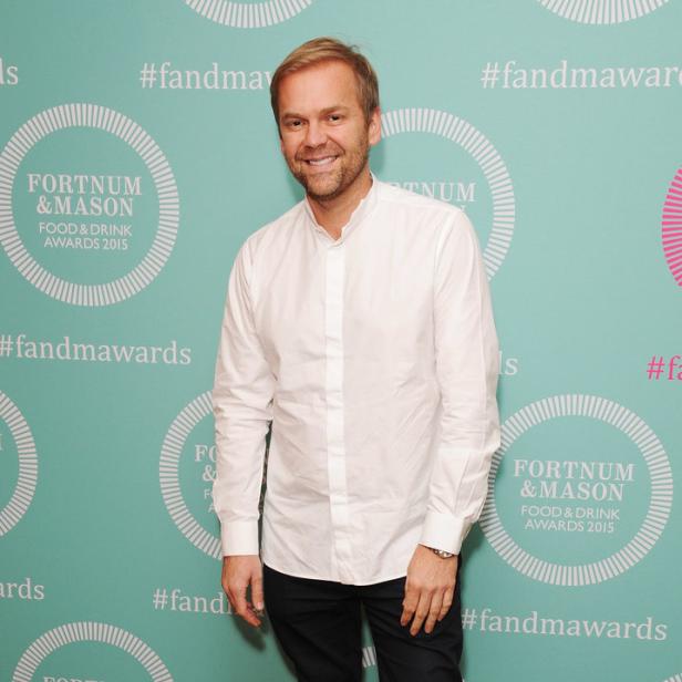 Ein Mann posiert vor einer Wand mit dem Logo der Fortnum & Mason Food & Drink Awards.