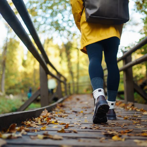 Frau geht im Herbstwetter über Brücke