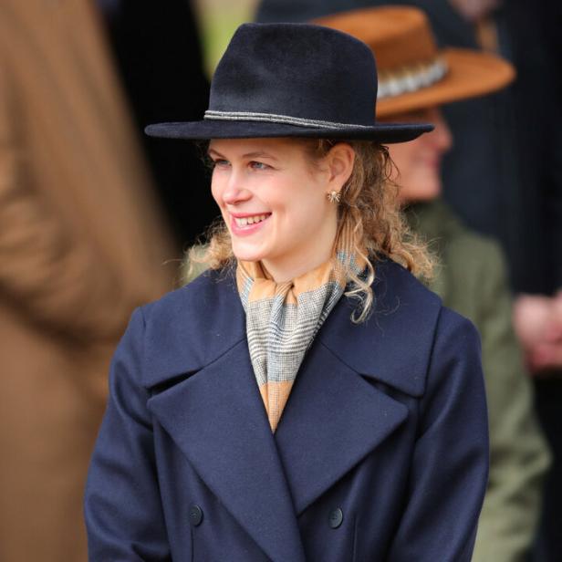 Lady Louise Windsor mit Hut und blauem Mantel lächelt.