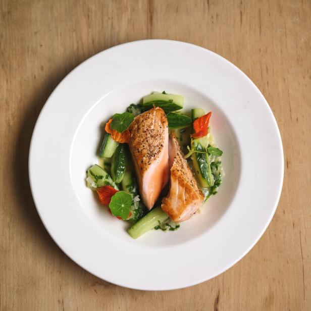 Gebratener Lachs auf gedünsteten Gurken.