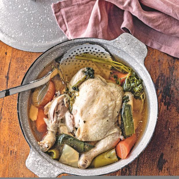 Eine hausgemachte Hühnersuppe mit Gemüse in einem Topf.