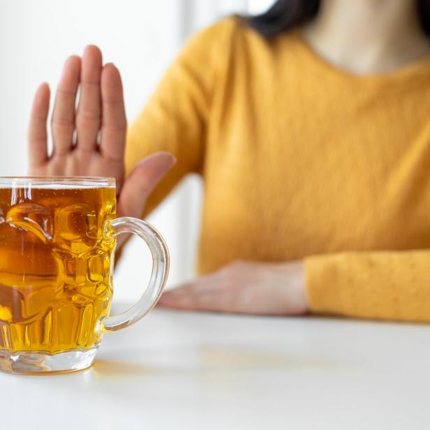Eine Frau lehnt ein Glas Bier ab.