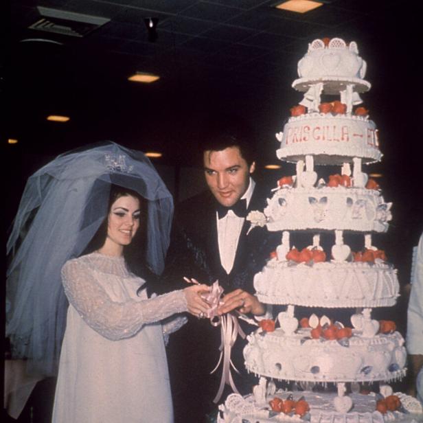 Priscilla Presley und Elvis schneiden ihre Hochzeitstorte an.