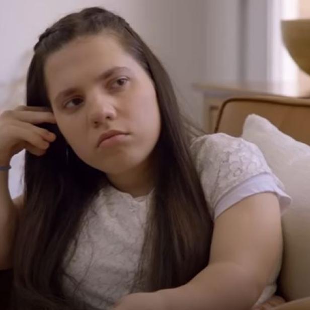 Natalia Grace Barnett sitzt auf einem Sofa, ihren Kopf lehnt sie an ihre Hand.