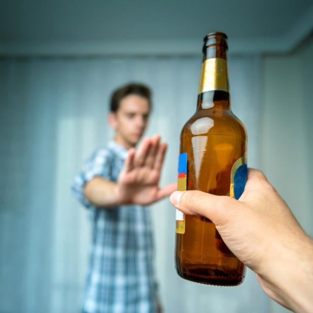 Ein Mann lehnt eine Bierflasche ab.