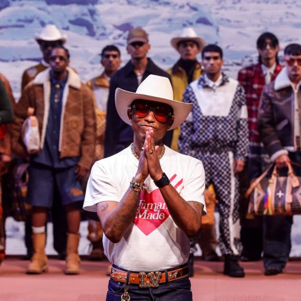 Pharrell Williams posiert mit Models bei einer Modenschau.