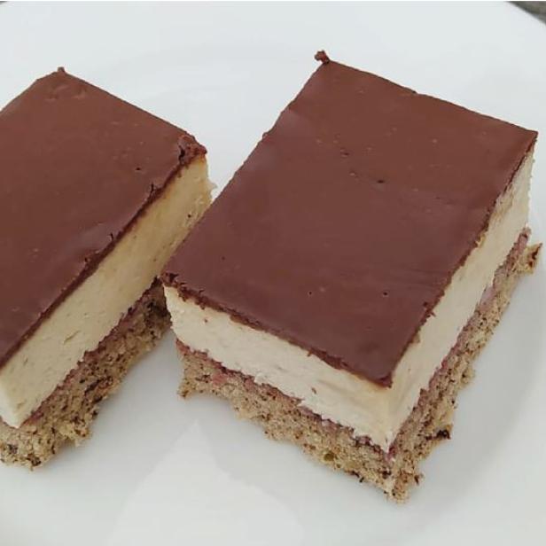 Zwei quadratische Kuchenstücke mit Schokoladenglasur auf einem Teller.