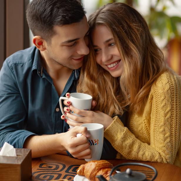 Paar in einem Café beim Date, kuschelt.