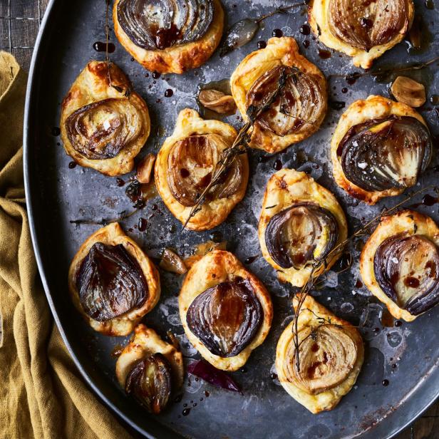 Zwiebeltartelettes mit Balsamico-Glasur und Thymian auf einem Backblech.