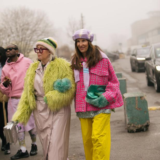 Zwei Frauen in farbenfrohen Outfits auf einer Straße.