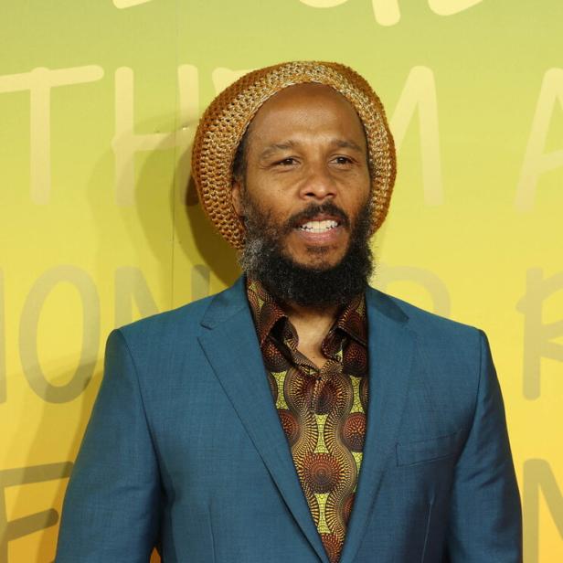 Ziggy Marley trägt einen Hut und einen blauen Anzug.