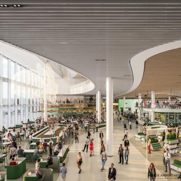 Innenansicht des Flughafens Wien mit Restaurants und wartenden Passagieren.