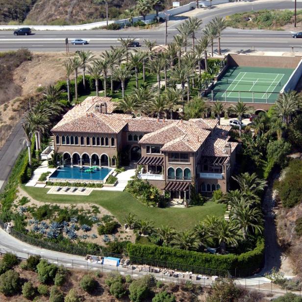 Die Villa von Cher mit Pool und Tennisplatz auf einem Hügel.