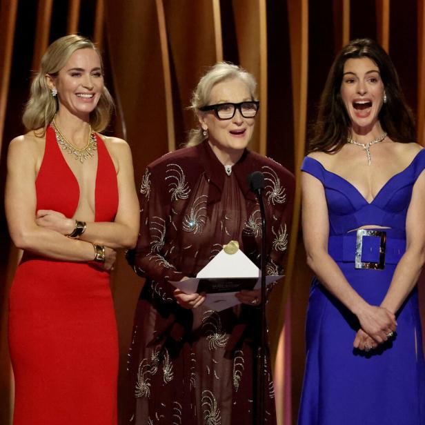Emily Blunt, Meryl Streep und Anne Hathaway stehen auf einer Bühne.