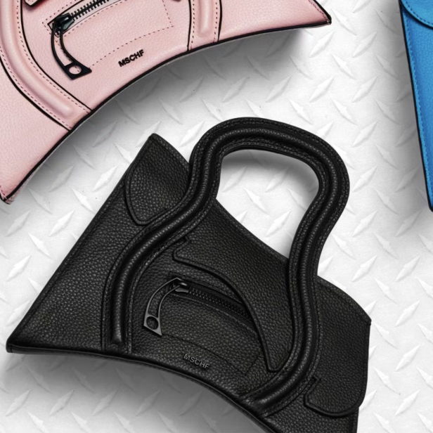 Vier MSCHF-Lederhandtaschen in Rosa, Blau, Schwarz und Orange auf einer strukturierten Oberfläche.