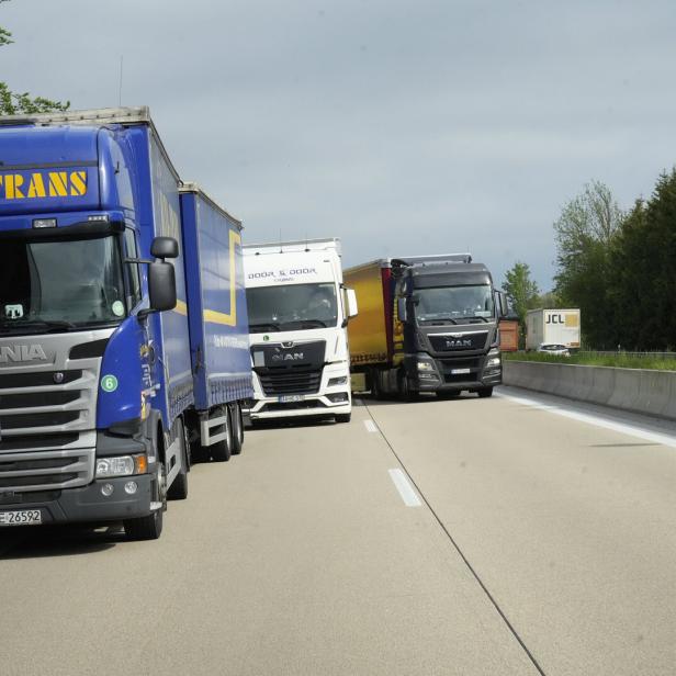 Mehrere Lastwagen stehen auf einer Autobahn im Stau.