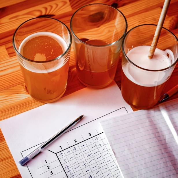 Drei Gläser mit Getränken und ein Pubquiz-Bogen auf einem Tisch.