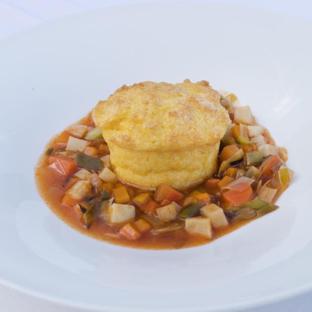 Ein Polenta-Auflauf auf einem Teller mit Gemüse.