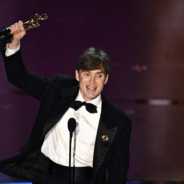 Cillian Murphy hält seinen Oscar in die Höhe.