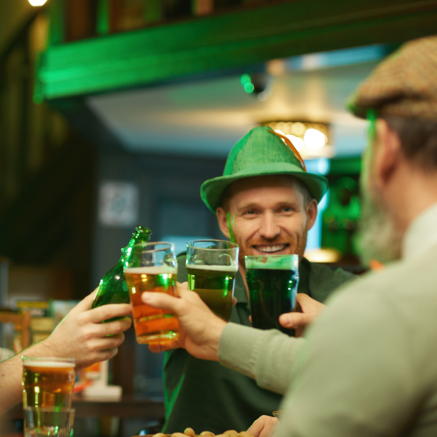 Drei Freunde stoßen in einer Bar mit Bier auf den St. Patrick's Day an.