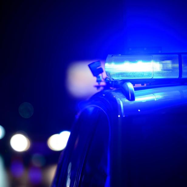 Blaulicht auf dem Dach eines Polizeiautos bei Nacht.