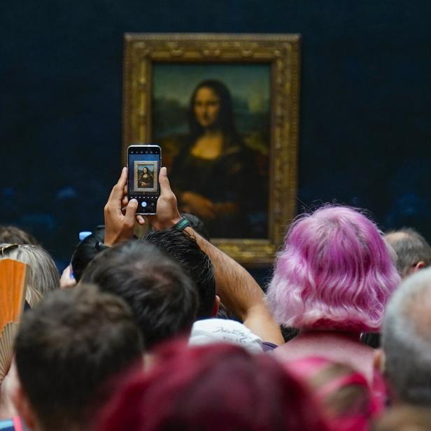 Besucher fotografieren die „Mona Lisa“ im Louvre.