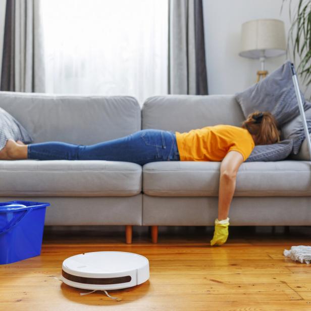 Erschöpfte Person liegt nach dem Putzen auf der Couch.
