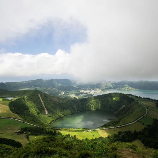 Blick auf die grüne Landschaft und einen Kratersee auf den Azoren.