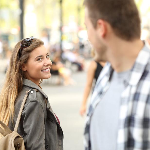 Junge Frau flirtet mit einem fremden Mann.