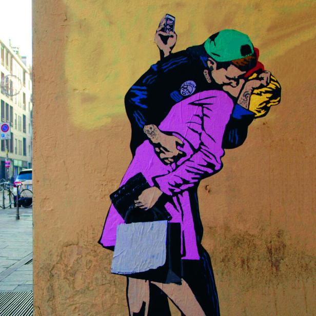 Ein Banksy-Graffiti zeigt zwei sich küssende Polizisten, von denen einer ein Handy hält.