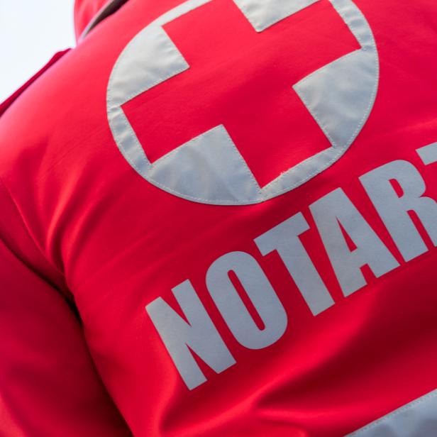 Ein Notarzt im Einsatz mit seinem Rücken zur Kamera.