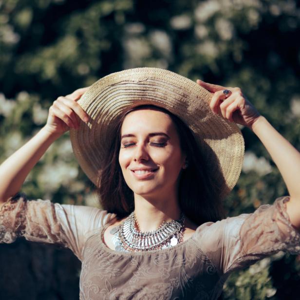 Eine Frau mit Hut genießt die Sonne.