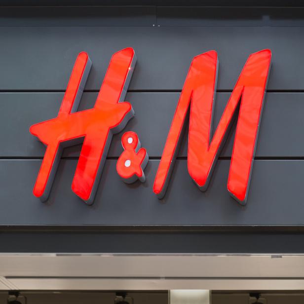 Das rote H&M-Logo an einer grauen Fassade.