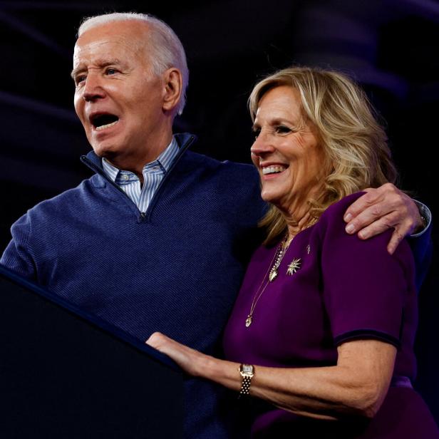 Joe Biden spricht am Rednerpult, während Jill Biden lächelt und ihre Hand auf seinen Arm legt.
