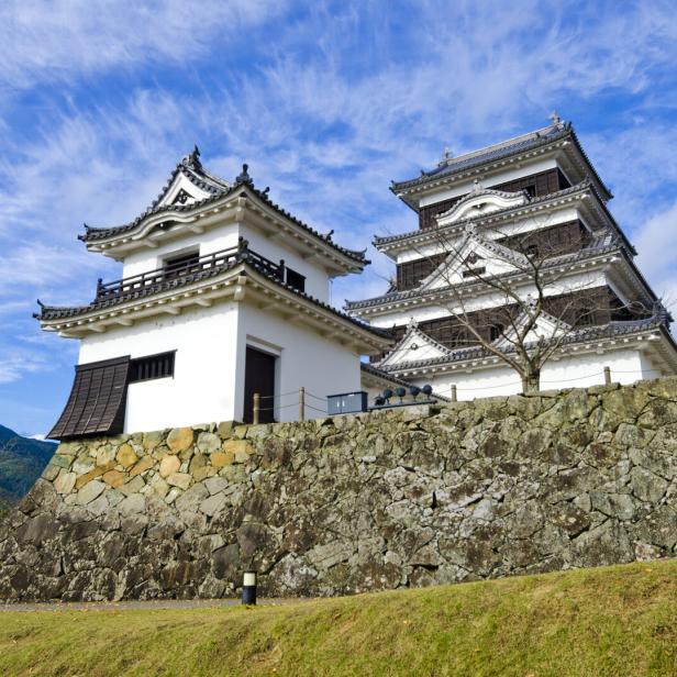Die Burg Ozu in Japan steht auf einer steinernen Anhöhe.