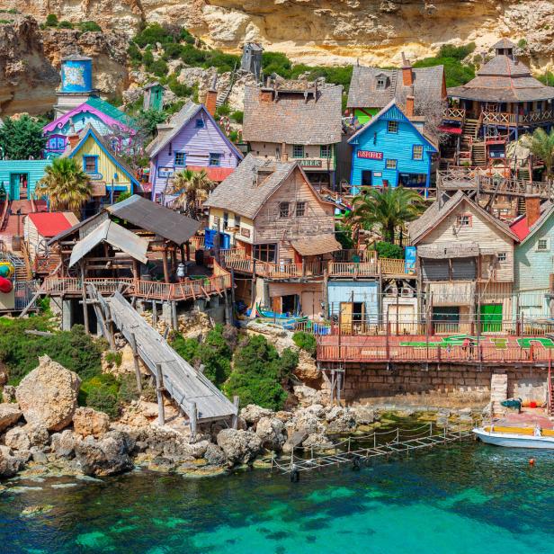 Das Popeye Village in Malta mit seinen bunten Häusern an einer felsigen Küste.