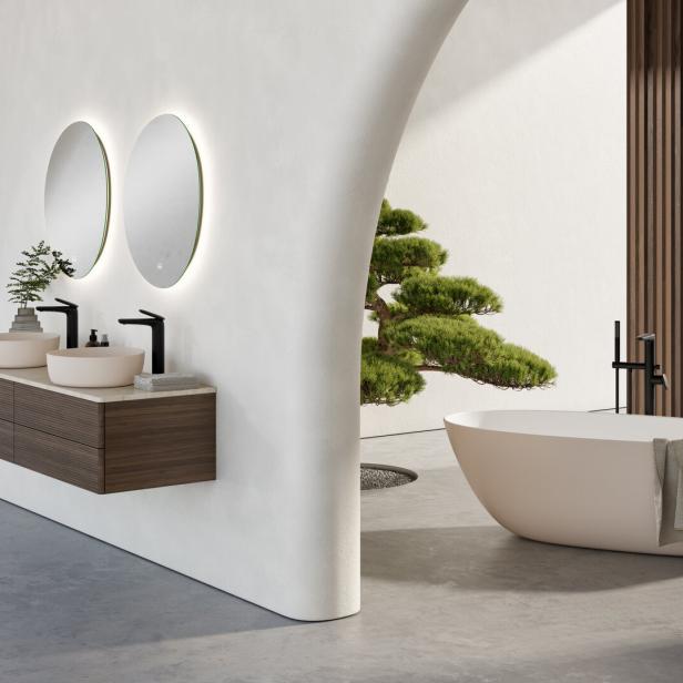 Ein modernes Badezimmer mit Doppelwaschbecken, freistehender Badewanne und einem kleinen Baum.