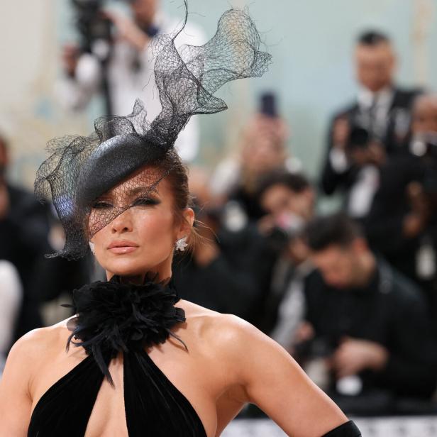 Jennifer Lopez trägt einen schwarzen Hut mit Schleier und ein schwarzes Kleid.