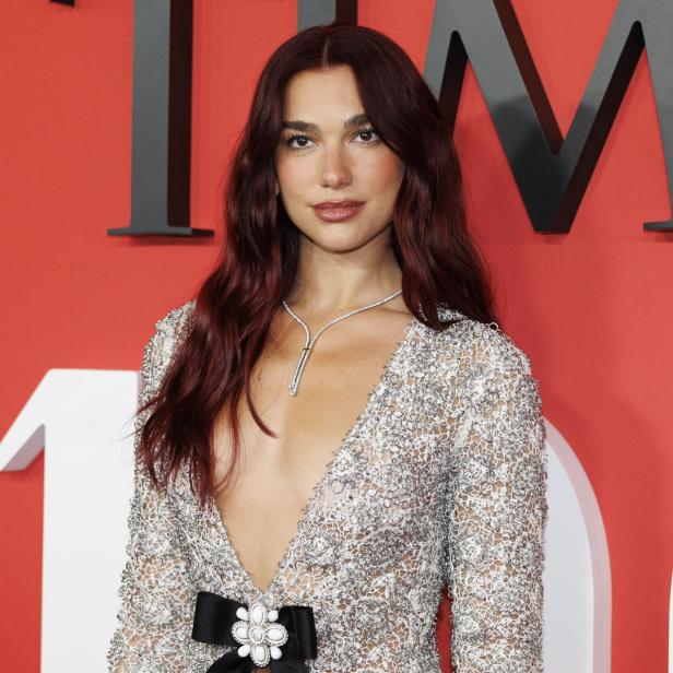Dua Lipa trägt ein glitzerndes Kleid mit tiefem Ausschnitt.