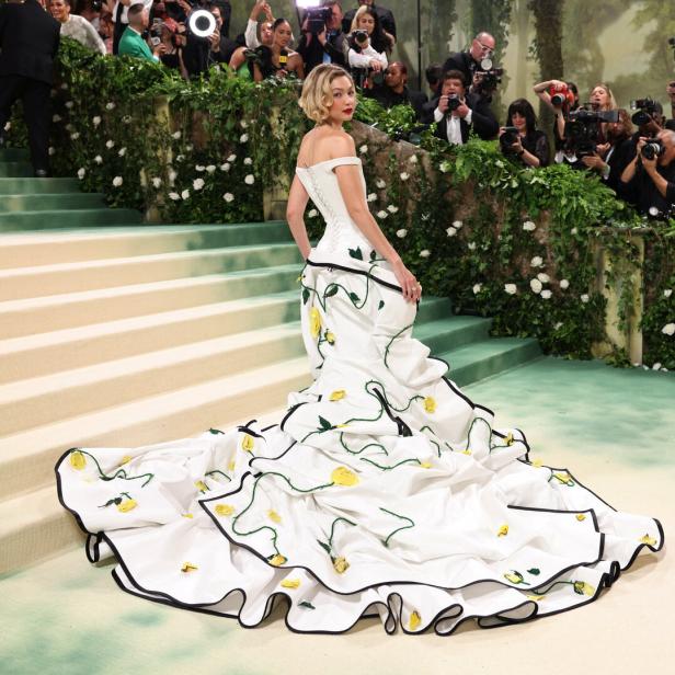 Eine Frau in einem weißen Kleid mit gelben Rosen auf der Met Gala.